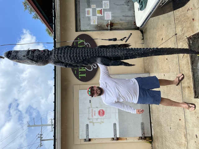 Florida hunter standing beside a harvested alligator after a guided hunt