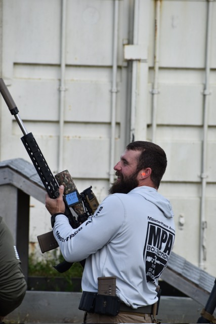 Precision rifle competitor carrying a competition rifle between stages